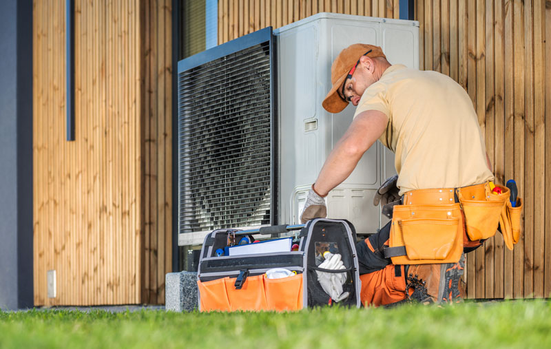 Heat-Pump-Maintenance Technician running maintenance on a heat pump